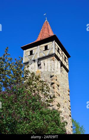 Vieille tour carrée à toit rouge, arbre en face, avec ciel bleu, à Ostheim vor der Rhön, Allemagne Banque D'Images