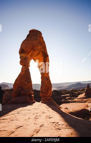 Le soleil jeter derrière Delicate Arch dans Arches National Park. Banque D'Images