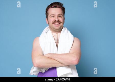 Happy smiling caucasian man with moustache avec porte-serviettes chauffant relaxant après l'entraînement. Aller dans le sport. Du visage positif l'émotion humaine. Studio shot Banque D'Images