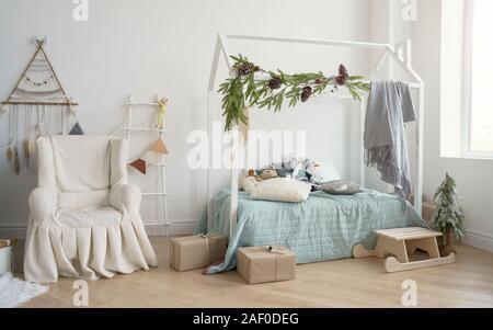 Chambre décorée avec un fauteuil couvert et chambre lit de forme. Banque D'Images