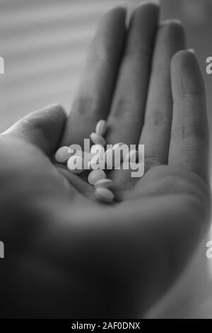 Pilules médical dans une jeune femme part. Photo en noir et blanc. Tre Banque D'Images