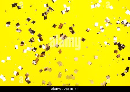 Argent chute confetti sur toile jaune. Maison de concept. Banque D'Images