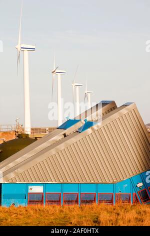 Éoliennes sur la côte ouest de Cumbria UK, avec une station d'épuration à l'avant-plan. Banque D'Images