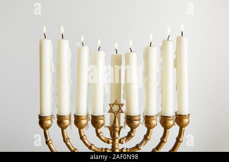 Les chandelles allumées dans la menorah sur Hanouka isolated on white Banque D'Images