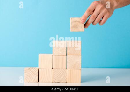 Portrait of businessman mettre cube de bois sur bleu Banque D'Images