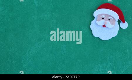 Le Père Noël était conçu face avec chapeau, barbe et moustache sur un fond vert fête with copy space Banque D'Images