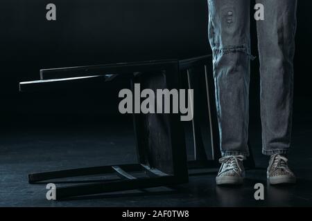 Portrait de femme debout près de la chaire tombé sur fond noir Banque D'Images