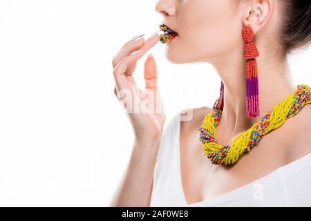 Vue partielle de girl à collier et boucles d'oreilles perles et toucher sur des lèvres isolated on white Banque D'Images