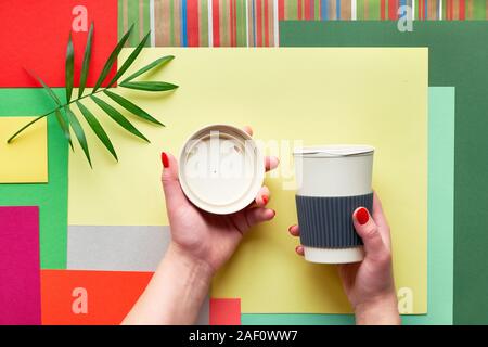Tasse à café en bambou (garder la tasse ou gobelet de voyage) avec couvercle de femmes sur papier rectangle multicolore géométrique abstrait arrière-plan avec la feuille de palmier. Creati Banque D'Images