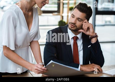 Portrait de blond woman holding folder près de bel homme barbu Banque D'Images