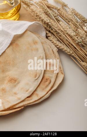 Pain lavash couvertes de blé près de serviette les pointes et de l'huile sur la surface blanche Banque D'Images