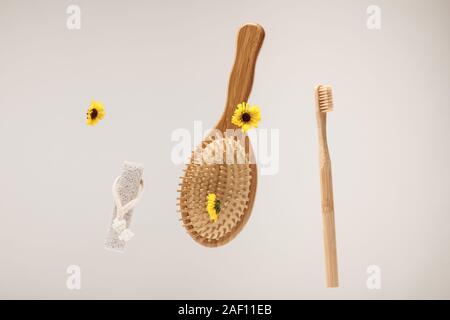 Pierre ponce, brosse à dents, brosse et fleurs jaune isolé sur gray Banque D'Images