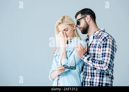 L'Homme à lunettes triste consolation fille isolée sur gray with copy space Banque D'Images