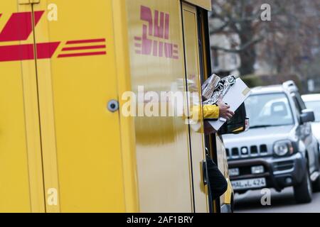 Halle, Allemagne. Dec 11, 2019. Un livreur de colis DHL quitte son véhicule dans l'Paulusviertel avec plusieurs envois. DHL s'attend à un nouveau record de nombre de colis pour les jours avant Noël. 11 millions de colis sont attendus par jour, la moyenne annuelle est de 5 millions de dollars par jour. Dans la Halle, la saison de Noël signifie 52 000 parcelles, qui sont remis à l'avant par le personnel chargé de l'exécution 90 portes chaque semaine. Crédit : Jan Woitas/dpa-Zentralbild/dpa/Alamy Live News Banque D'Images