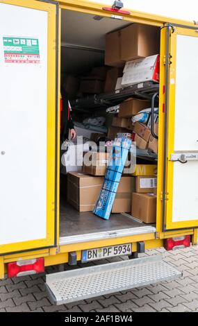 Halle, Allemagne. Dec 11, 2019. Colis et petits colis sont empilés dans un véhicule de livraison DHL. DHL s'attend à un nouveau record de nombre de colis pour les jours avant Noël. 11 millions de colis sont attendus par jour, la moyenne annuelle est de 5 millions de dollars par jour. Dans la Halle, la saison de Noël signifie 52 000 parcelles, qui sont remis à l'avant par le personnel chargé de l'exécution 90 portes chaque semaine. Crédit : Jan Woitas/dpa-Zentralbild/dpa/Alamy Live News Banque D'Images