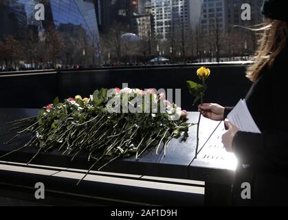 New York, États-Unis. Dec 12, 2019. Déposer des fleurs de deuil à l'miroirs d'eau à l'assemblée annuelle de la cérémonie du souvenir au Mémorial National du 11 septembre et Musée à l'occasion du 26e anniversaire de l'attentat contre le World Trade Center de 1993 qui a tué six blessés et plus de 1 000 le 26 février 2019, dans la ville de New York. Dans le cadre de la cérémonie, les membres des familles des victimes lire à haute voix leurs noms et lieu roses à leurs noms sur le monument. Photo de John Angelillo/UPI UPI : Crédit/Alamy Live News Banque D'Images