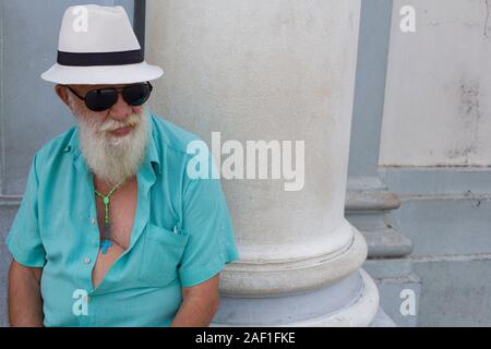 Diamantina, Minas Gerais, Brésil - 28 janvier 2016 : homme religieux brésilien portant un chapeau de Panama, une chemise verte ouverte, des lunettes de soleil et des perles catholiques Banque D'Images