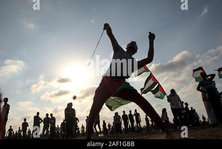 Khan Younis, à Gaza. Dec 12, 2019. Un Palestinien utilise une fronde pour lancer des pierres au cours d'affrontements avec les forces israéliennes de l'autre côté de la clôture de barbelés suite à une manifestation le long de la frontière avec Israël à l'est de Khan Younis dans le sud de Gaza, le vendredi 13 septembre, 2019. Selon des sources médicales, 29 Palestiniens ont été blessés au cours de l'affrontement. Photo par Ismael Mohamad/UPI UPI/Alamy Crédit : Live News Banque D'Images