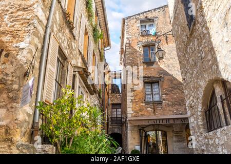 Une petite cour bondée de maisons et boutiques dans le centre touristique du village médiéval de Tourrettes sur Loup dans le sud de la France. Banque D'Images