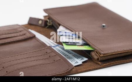 Portefeuille marron avec des cartes de crédit et de centaines de dollars sur fond blanc. Close-up Banque D'Images