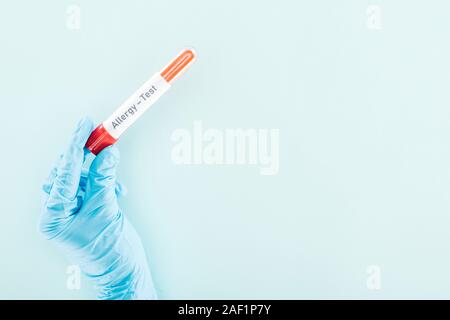 Portrait du docteur holding sample en tube à essai test allergie isolée inscription sur bleu Banque D'Images