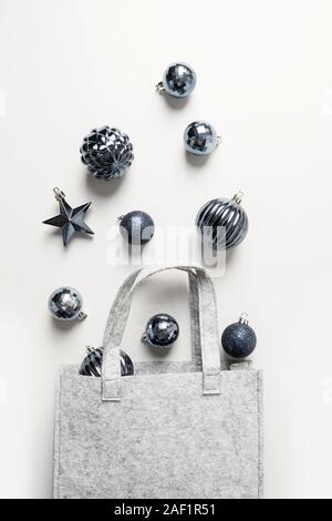 L'impression de Noël sac d'hiver classique avec boules bleues sur fond gris. Xmas shopping concept. Vue de dessus, une télévision. Couleur tendance, Pantone 2020. Ve Banque D'Images