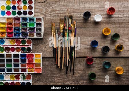 Vue de dessus de la peinture de couleur brun en bois sur palettes de surface avec de la gouache et pinceaux Banque D'Images