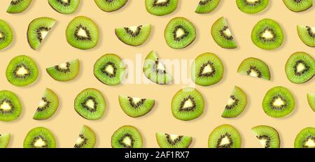 Tranches de kiwi macro. Les kiwis mûrs isolé sur fond jaune. Banque D'Images