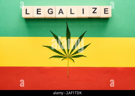 Vue du dessus de la feuille de cannabis et blocs en bois avec légaliser le lettrage sur fond drapeau Rastafari Banque D'Images