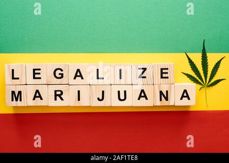 Vue du dessus de la feuille de cannabis et des blocs de bois à légaliser la marijuana le lettrage sur drapeau Rastafari Banque D'Images