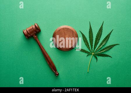 Vue de dessus de la marijuana vert feuille avec wooden gavel sur fond vert Banque D'Images