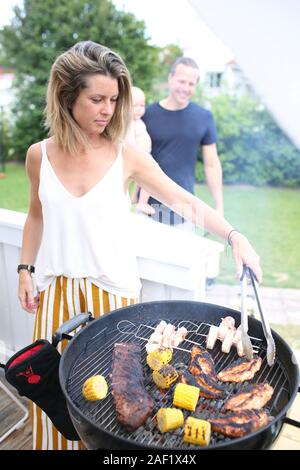 Woman preparing food sur barbecue Banque D'Images