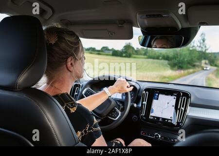 Femme au volant voiture avec GPS intégré au tableau de bord Banque D'Images