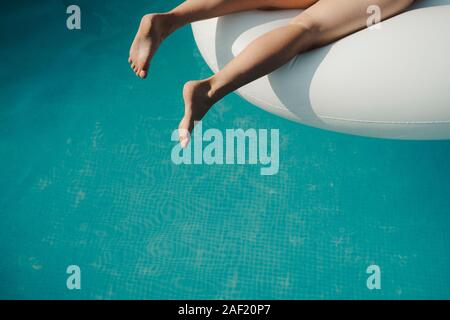 Jambes de femme au-dessus de l'eau en piscine Banque D'Images