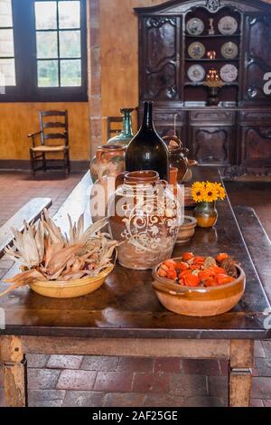 Vieille table de chêne rempli de poterie et des fruits dans une vieille cuisine du 17e siècle Banque D'Images