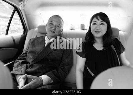 Mature Asian businessman et mature Asian woman explorer la ville ensemble Banque D'Images