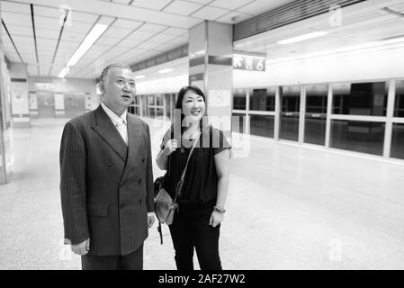 Mature Asian businessman et mature Asian woman explorer la ville ensemble Banque D'Images