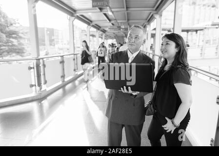 Mature Asian businessman et mature Asian woman explorer la ville ensemble Banque D'Images