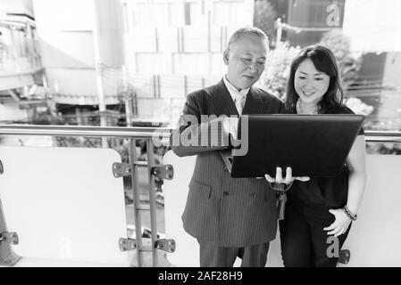 Mature Asian businessman et mature Asian woman explorer la ville ensemble Banque D'Images