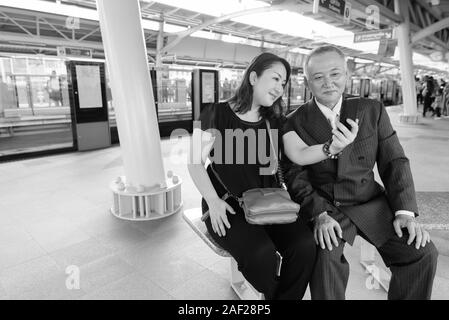 Mature Asian businessman et mature Asian woman explorer la ville ensemble Banque D'Images