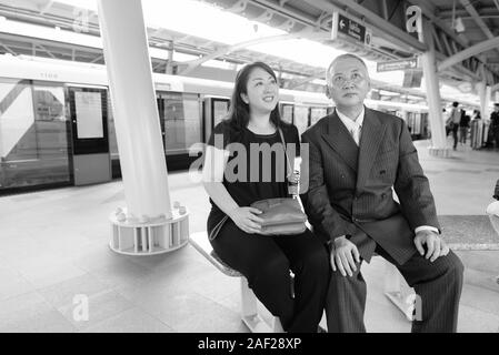 Mature Asian businessman et mature Asian woman explorer la ville ensemble Banque D'Images