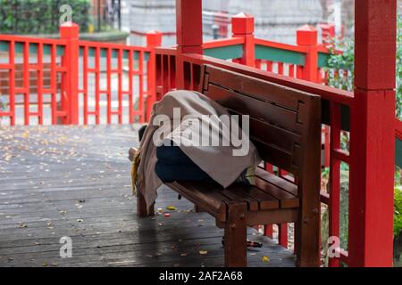 Sans-abri dormant sur un banc en Chine Ville de Manchester en Angleterre 2019 Banque D'Images