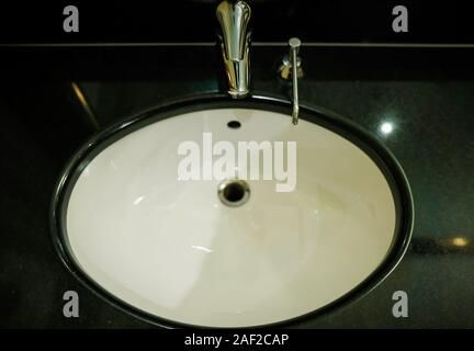 Profondeur de champ (selective focus) avec l'image d'un lavabo, robinet et d'un distributeur de savon dans un hôtel une salle de bains privative. Banque D'Images