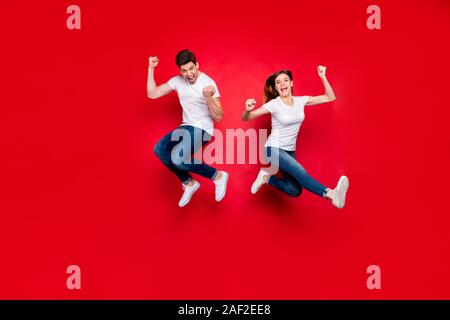 La taille du corps sur toute la longueur de la photo saut positif de joie joie excité copine copain portant des jeans denim blanc T-shirt chaussure Banque D'Images