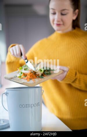 Femme Fabrication du compost à partir de restes de légumes dans la cuisine Banque D'Images