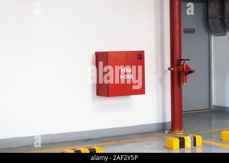 Les lances à incendie emballés à l'intérieur d'urgence rouge fort au mur Banque D'Images