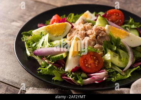 Salade avec des oeufs, du thon et légumes sur table en bois Banque D'Images