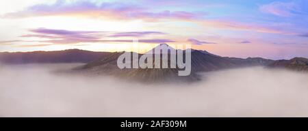Vue de dessus, une superbe vue panoramique du Mont Semeru, Le Mont Bromo et le Mont Batok entourée de nuages pendant un beau lever de soleil. Banque D'Images