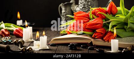 Tulipes orange sur le vieux livre Banque D'Images