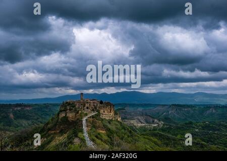 Civita di Bagnoregio, un ancien établissement étrusque, situé au sommet d'un plateau de tuf volcanique, sombres nuages d'orage dans la distance Banque D'Images